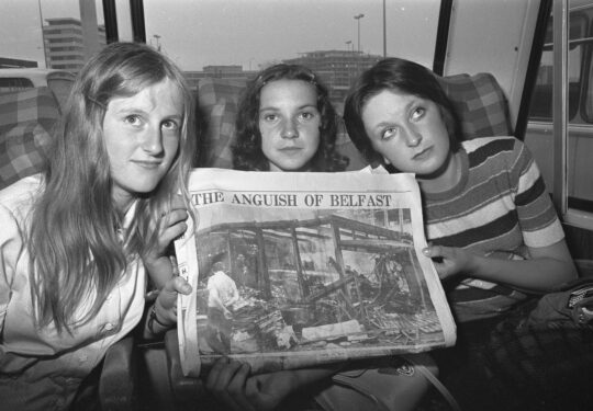Drie vrouwen houden een krant op
